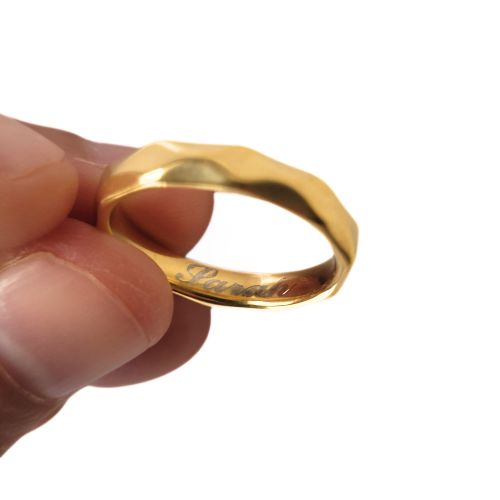 Konzentrieren Sie sich auf das perfekt glatte Innere des goldenen Stahlrings, um einen benutzerdefinierten Lasergravur aufzunehm