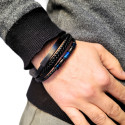 Schließen Sie oben auf dem Handgelenk einer Mannhand in der Tasche, markiert das Lederarmband 3-Kabeln und sein modernes Design.