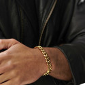 Man with arms crossed outside, highlighting the beautiful presence and brightness of the golden cubine mesh bracelet.