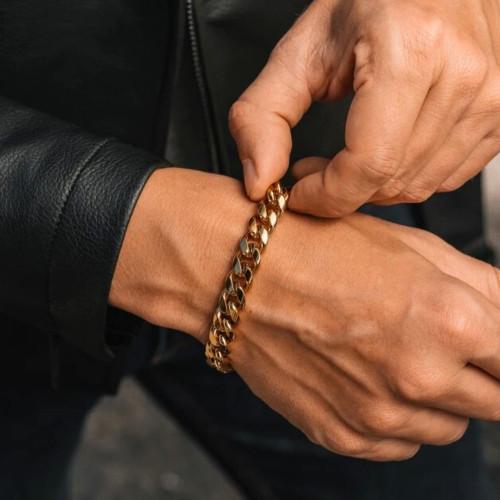 Nahaufnahme auf dem Handgelenk eines Mannes, der die Dicke von 9 mm und den Reflexionen des Gold-Edelstahl-Armbands darstellt.