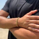 Hombre con una chaqueta de cuero negra ajustando su brillante pulsera de oro dorado con Malla de Miami Cuba.