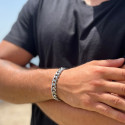 Hombre que llevaba una chaqueta de cuero negra y arboriendo con la brillante pulsera de acero con Mesh Cuban Miami.