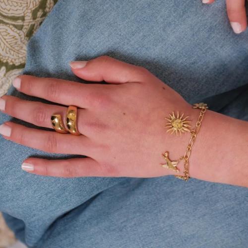 Doppelter Doppel-Drop-Ring und gekrümmte Frau in goldenem Edelstahl - minimalistisch und modern