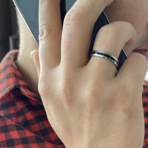 Primo piano dell'anello di alleanza con la mano di un uomo, evidenziando l'intensità del contrasto della scanalatura
