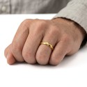 Bague anneau minimaliste dorée portée à l'annulaire d'un homme pour un style élégant et chic au quotidien