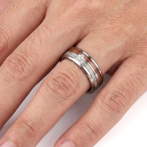 Autre angle de la bague en acier et bois portée au doigt par un homme illustrant son allure résolument moderne