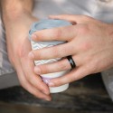 Anillo de la alianza moderna y orgánica que llega al anular de un hombre por un estilo elegante y único