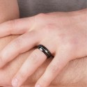 Anillo de bodas de acero negro y madera que llegan al dedo que ilustra la presencia masculina y el diseño moderno