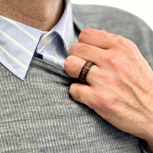 Anillo de anillo de acero negro con la moderna banda de núcleo de madera KOA transportada por un hombre