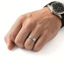 Der schicke Ring in Wolfram mit 3 gekrümmten Bändern, die elegant von einem Mann getragen werden