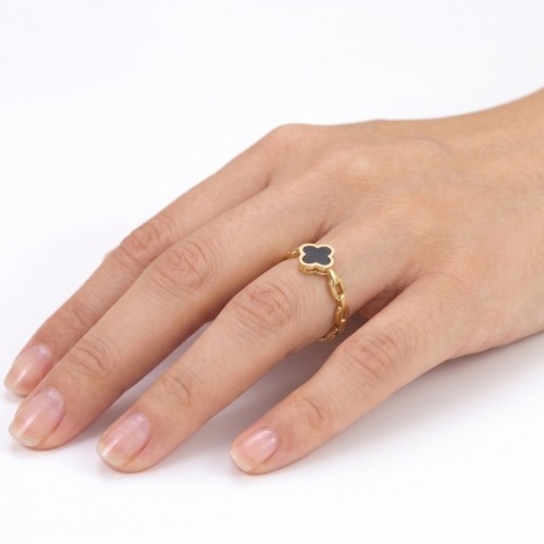 Vista del anillo manuscrito de una mujer, destacando el brillo de los enlaces de oro y la profundidad del trébol