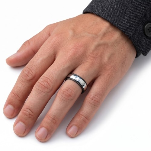 anello trasportato da un uomo, evidenziando i riflessi ratio della banda argento contrastante con bordi neri