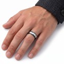 ring carried by a man, highlighting the satin reflections of the contrasting silver band with black borders