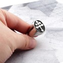 Gros plan de la bague portée à la main, mettant en valeur l'éclat de l'acier poli contrastant avec le fond texturé sombre