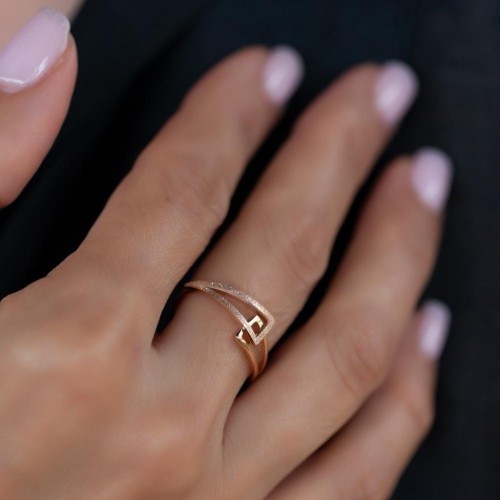 Anillo moderno con dos triángulos de oro rosa con elegancia con elegancia con el anular de una mujer