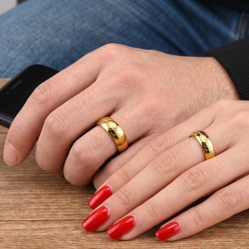 Einzigartiger Ring in Goldwolfram, der von einem Paar getragen wird, um eine epische und originelle Hochzeitsbündel zu symbolisi