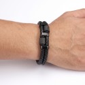Bracelet en cuir noir et fermoir acier noir avec cylindres porté au poignet d'un homme