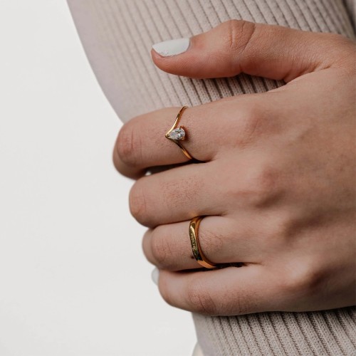 Bague hexagonale dorée gravée Je t'aime portée au doigt d'une femme pour une déclaration d'amour romantique et élégante