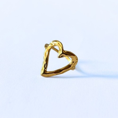 Vista del excelente acabado de este anillo abierto martillado en el corazón de acero dorado, que cuelga suavemente la luz.