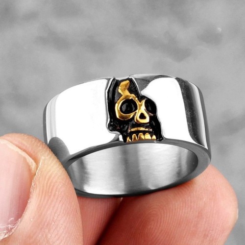 Bague large biker demi-crâne en acier inoxydable dorée portée au doigt par un homme, un style motard et authentique.