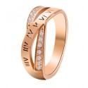 Gros plan de la bague en acier or rosé, montrant les chiffres romains gravés et l'éclat des cristaux.