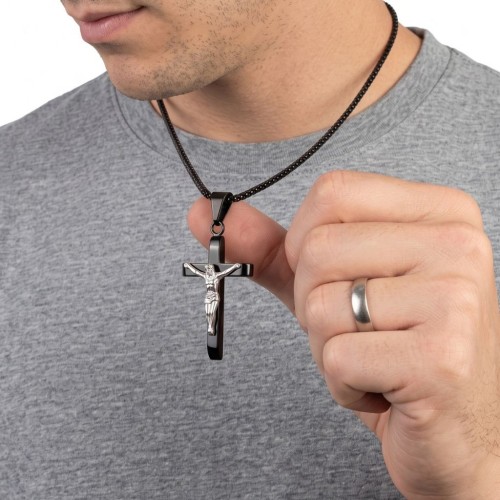 Nahaufnahme eines Mannes, der seinen schwarzen Kreuzanhänger mit Silber Jesus Christus hält, der die Proportionen des Juwels dar