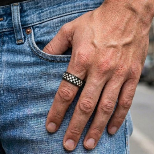 Homme portant une bague anti-stress noire avec anneau rotatif motif drapeau à damier, la main posée sur la poche de son jean