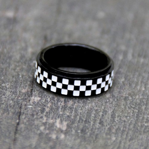 Dettaglio dell'anello dell'uomo anti-stress nero con l'acciaio nero con la bandiera a scacchi dell'anello rotante posizionato su