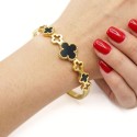 Woman wearing a rigid baked stainless steel bracelet, decorated with several clovers for an original and modern style