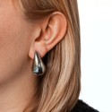Close-up view showing the perfect positioning of the tear-shaped earring on the lobe of the female ear.