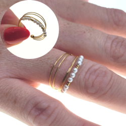 Bague ouverte femme acier doré à l'or fin anneaux rassemblés perles blanches portée