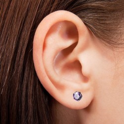 Pendientes redondos de acero en colores morados que lleva una mujer