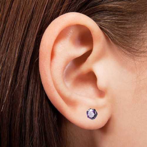 Orecchini tondi in acciaio nei colori viola indossati da una donna