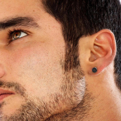 Pendientes redondos de acero en color negro usados por un hombre
