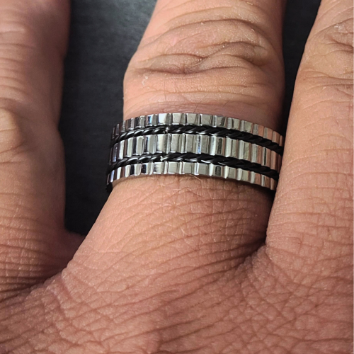 Bague anneau cranté en titane et 2 filins noirs torsadés portée par un homme