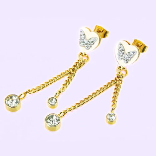 Woman golden gold earrings end heart butterfly chain zircons pink background