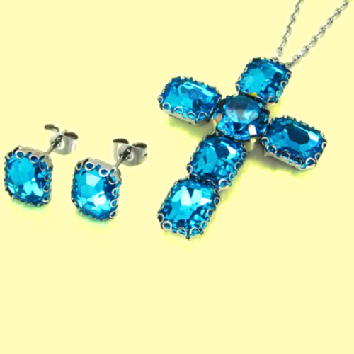 Cross pendant chain set and women's steel earrings with blue crystals on a yellow background