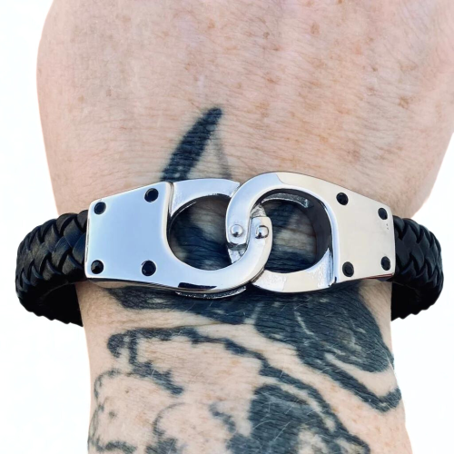 Pulsera de cuero unida por un dúo de esposas con cierre de acero inoxidable usadas por un hombre