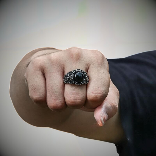 Demonstration of the relief and the presence of the black stone steel ring on a daily basis on a masculine hand.