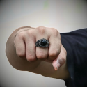 Demonstration der Erleichterung und der Anwesenheit des schwarzen Steinstahlrings täglich auf einer männlichen Hand.