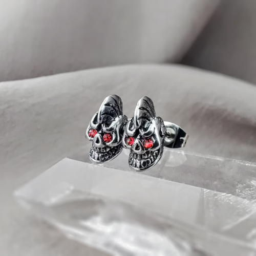 Se presentan un par de pendientes de calavera con ojos rojos de acero para moteros