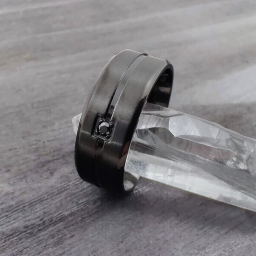 Se presenta anillo de compromiso para hombre con banda central de acero negro