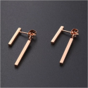 Pair of women's earrings with two dangling steel bars, pink gold color, black background