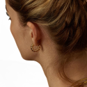 Gold-gold steel creole earrings with twisted stem worn by a back woman