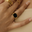 Anillo de sello de acero chapado en oro con ónix negro usado por una mujer