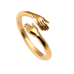 Modern wife ring in gilded stainless steel shaped with two hands enclosed on white background