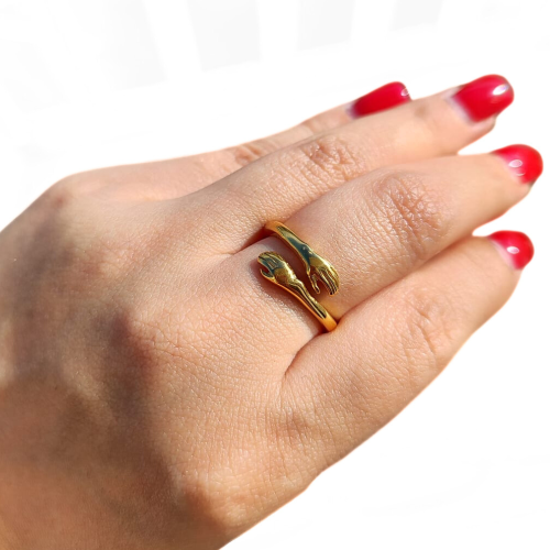 Nahaufnahme des Handtringrings einer Frau, die die Brillanz des feinen Goldfurniers durch Ionisierung unter Licht hervorhebt