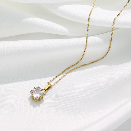 Necklace for golden steel woman posed on a white silk, highlighting its lonely zirconium squared pendant.
