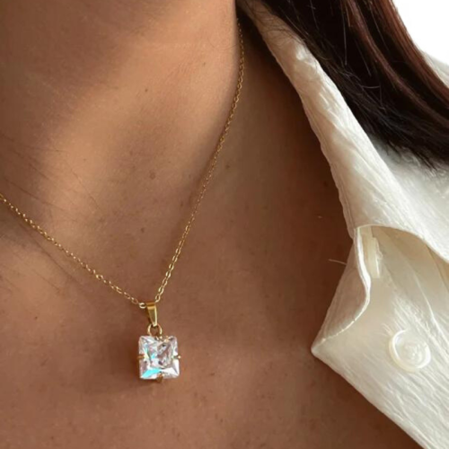 Mujer que llevaba el collar de oro del cuello de acero con su colgante de suelo cuadrado brillante perfectamente imitando el dia
