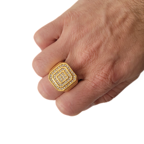 Goldener Ritterpflaster von Zirkoniumoxiden, die von einem eleganten Mann zum Finger gebracht werden.